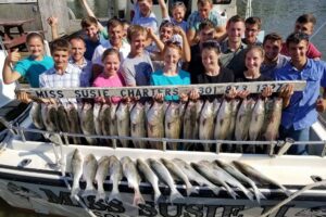 Large group on the fishing charter showing off their fish from the Chesapeake Bay.