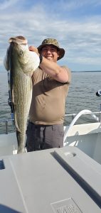 Man catches big Rockfish (Striped Bass) on the Chesapeake Bay Maryland.